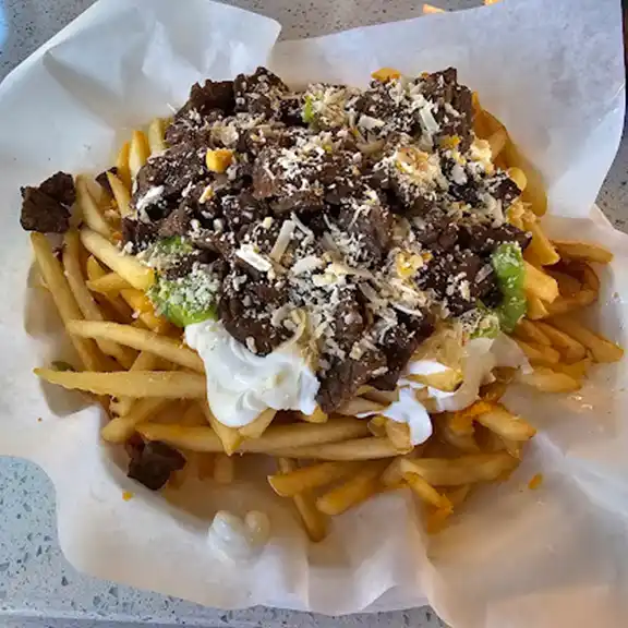 Large carne asada fries loaded with steak, cheese, guacamole, and sour cream