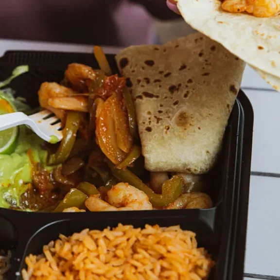 Mexican combo plate with grilled meat, rice, and tortillas
